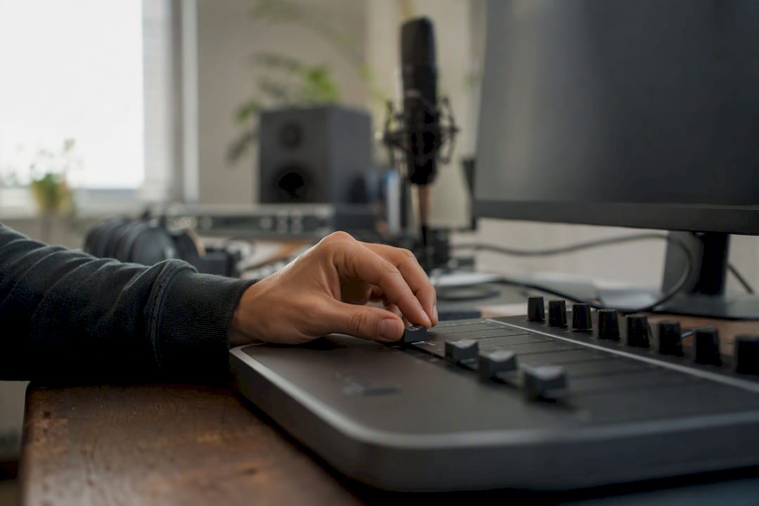 Welke DAW-controller kies je voor jouw manier van werken? 3 Hand die schuifregelaar van DAW-controller in studio bedient